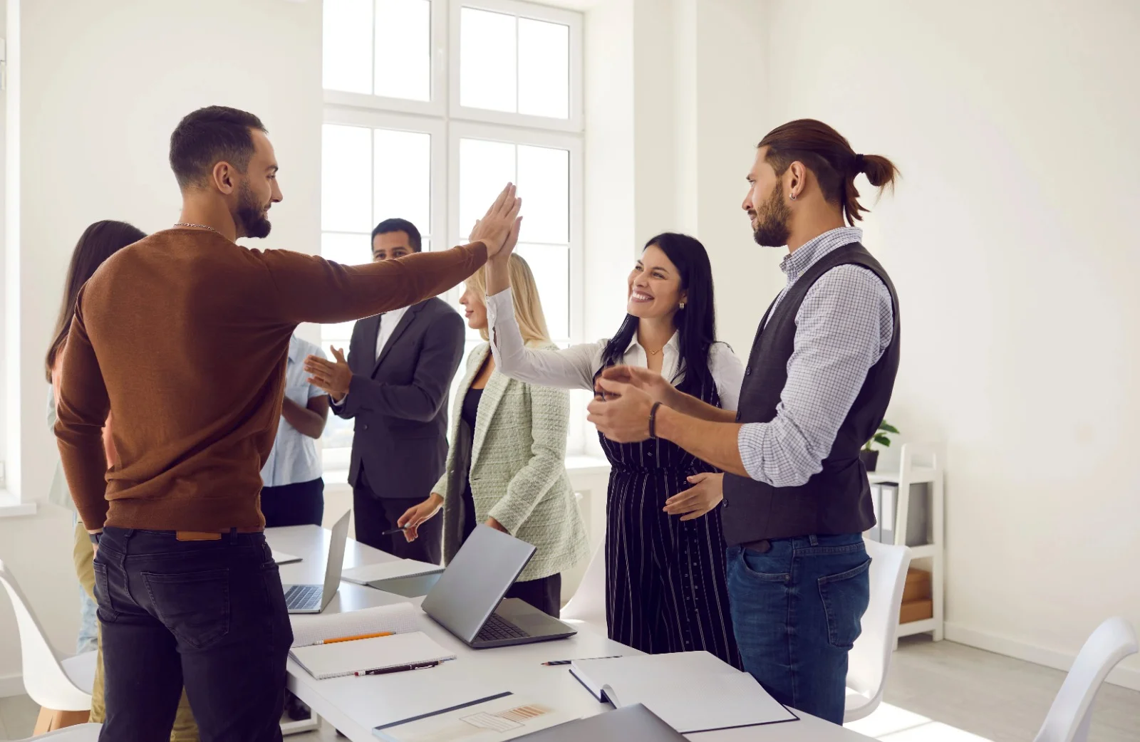 Diverse team members celebrating success in a modern office